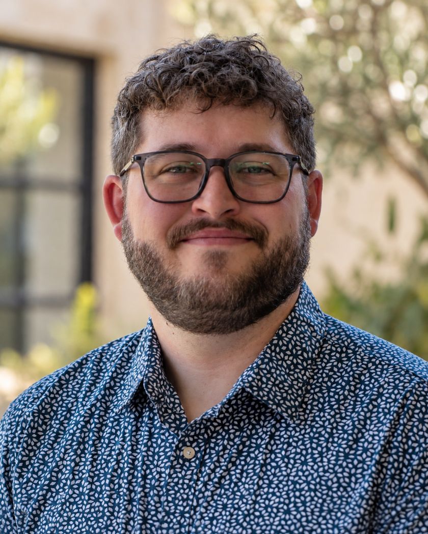 Trevor, founder of Drip Social, smiling outdoors in a navy patterned shirt